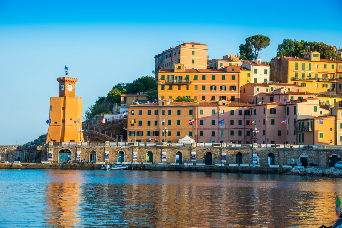 Sunset light illuminating traditional architecture of Rio Marina town - comune in Province of Livorno of Italian region in Tuscany.